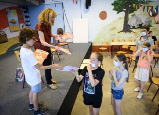 Wethouder Corine Verver reikt magazines uit over jonge mantelzorgers